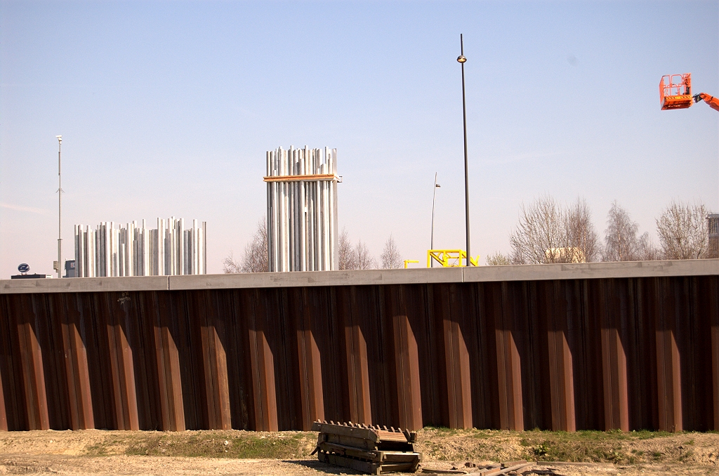 20090321-133827.jpg - De eerste paketten aluminium buizen zijn afgeleverd op het werkvak tussen KW 13 (aansluiting Veldhoven) en KW 14 (Meerenakkerweg). Ze gaan deel uitmaken van de geluidsschermen langs de hoofdrijbanen. Er lijken twee lengtecategorieen te worden toegepast.