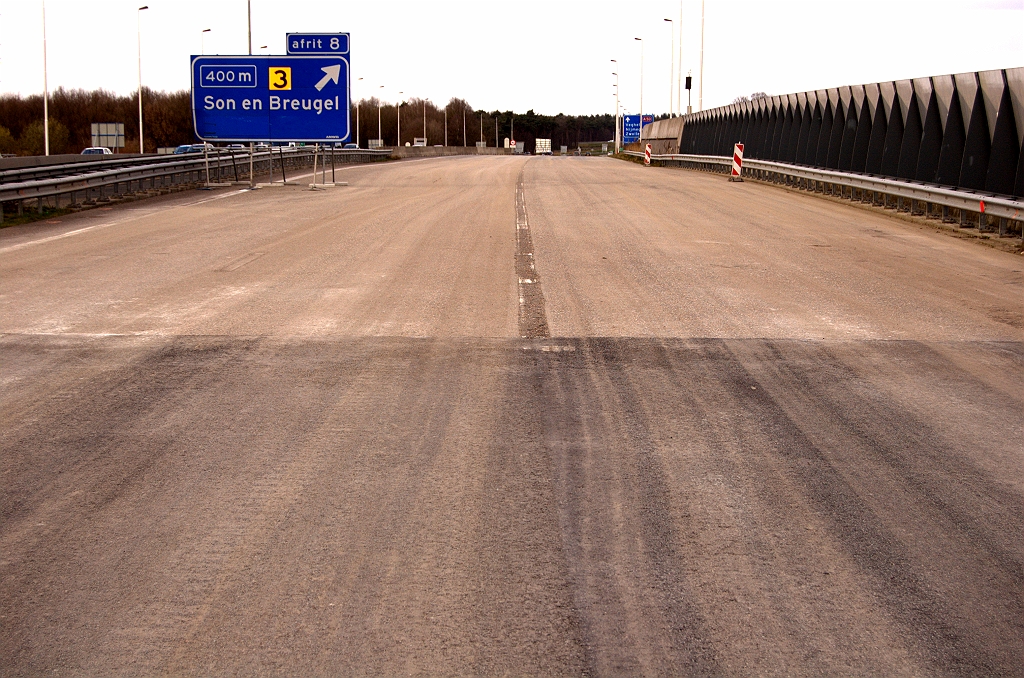 20090322-141234.jpg - Oude markering weggestraald of -gefreesd op de brug over het Wilhelminakanaal, zodat er een tijdelijke 4+0 rijstrookindeling kan worden aangebracht. Het nieuwe, dichte asfalt is vlak aangesloten op het bestaande zodat we hier in eerste instantie geen ZOAB gaan krijgen.