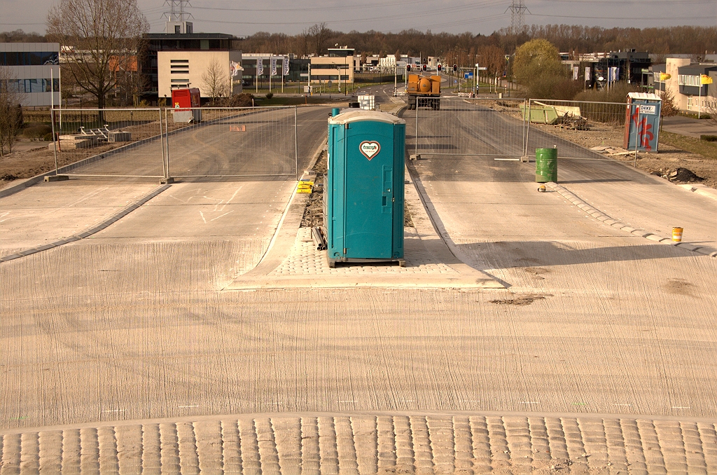 20090322-163143.jpg - Van betonnen rotonde naar de asfalt rijbanen naar/vanaf het bedrijventerrein. Rijbaan voor het chemisch toilet langs lijkt weer een spijtoptantvoorziening.