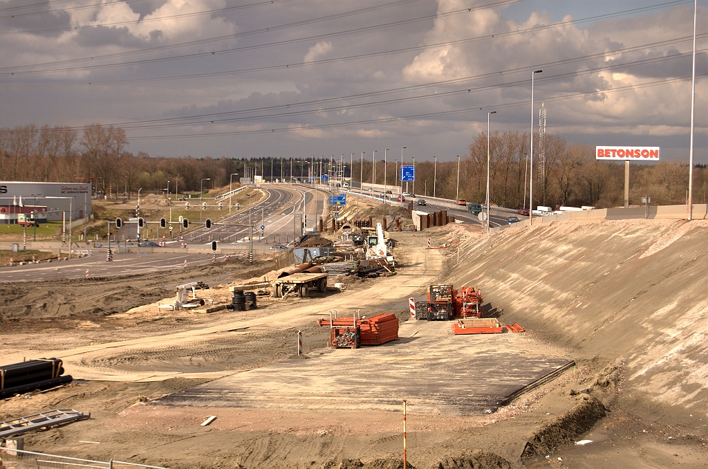 20090329-145100.jpg - Een weids overzicht vanaf het talud naar KW 43 met de verlaten A50 slingerfasering, de begraven nieuwe oostelijke A50 rijbaan, en de nieuwe fasering over KW 41.  week 200911 