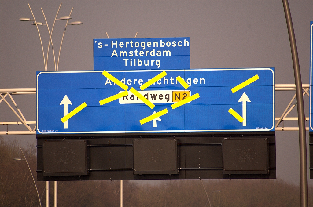 20090403-083416.jpg - De voorganger van dit bord heeft er drie maanden gehangen en is de afplakstatus nooit ontstegen. Men heeft dus bedacht dat de "Randweg Eindhoven" moet worden vervangen door de "Randweg N2". Op een aantal  nieuwe borden in kp. Ekkersweijer  kwamen we die aanduiding als eerste tegen.  week 200848 