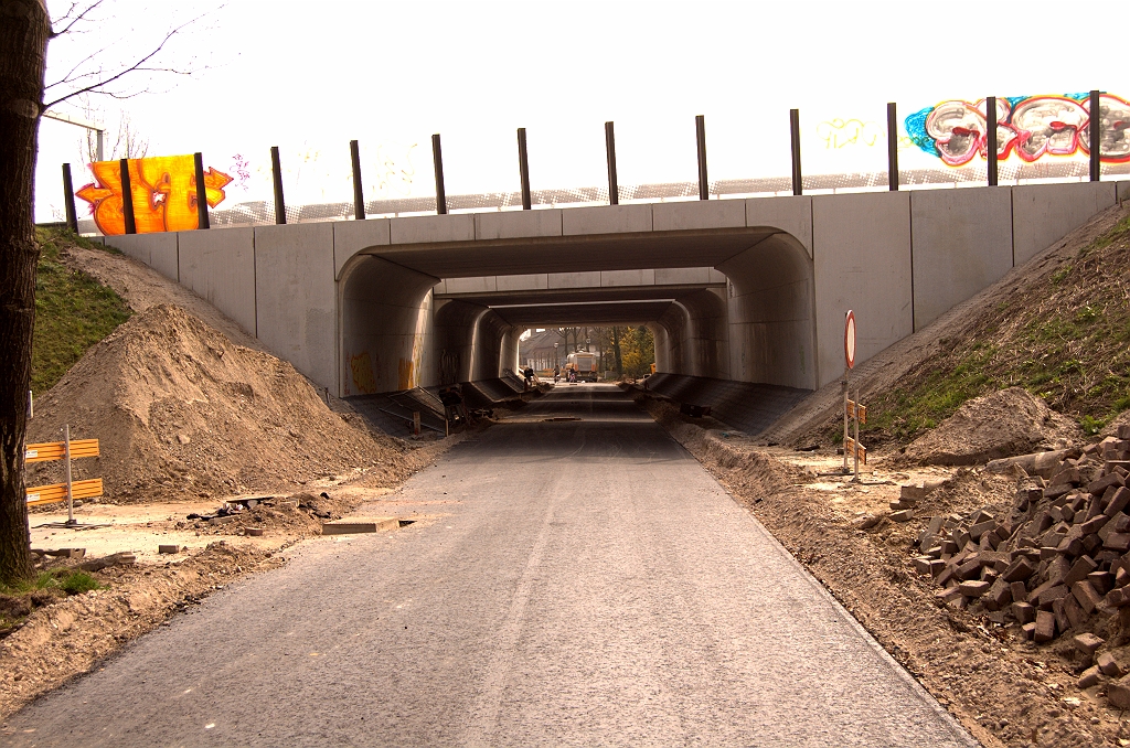 20090404-143455.jpg - Ingrijpendere wijzigingen voor het vooral langzaam verkeer dat onder KW 29 doorgaat: een gloednieuwe rijbaan. Aan Eindhovense zijde heet dit straatje "Velddoornweg", en het nieuwe asfalt loopt daar nog honderden meters verder door. Kennelijk wordt de vernieuwing van de viaducten ook aangegrepen om stukken onderliggend wegennet te vervangen.  week 200907 