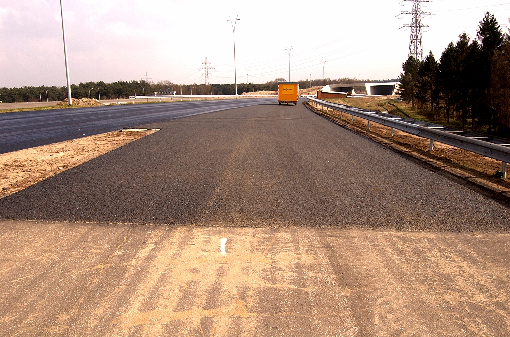 20090405-150519.jpg - Terug naar de tijdelijke bypass. Die komt hier uit op de nieuwe hoofdrijbaan in de richting Maastricht. De bypassrijbaan is uitgevoerd in dicht asfalt, maar krijgt opeens ZOAB bij de samenvoeging. Dat hebben we vaker gezien in bijvoorbeeld slingers tussen parallel- en hoofdrijbanen.