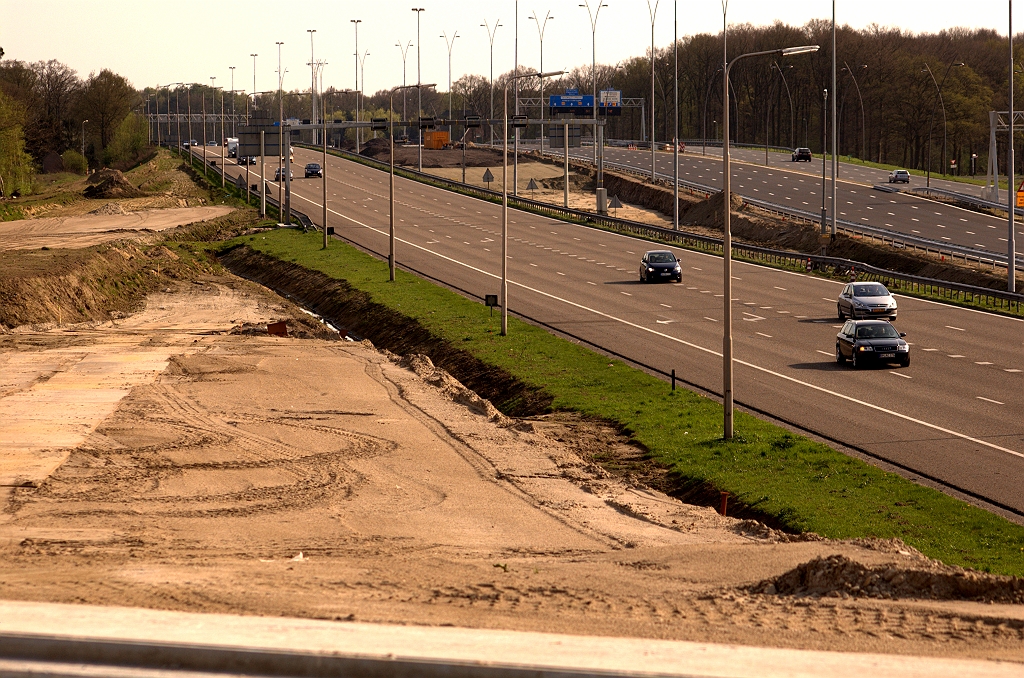 20090411-165236.jpg - Aardig te zien hier hoe de oude A2 rijbaan in de weg ligt om zowel de parallelbaan (cunet linksboven) als de nieuwe hoofdrijbaan (taps toelopende zandstrook in het midden) te kunnen aansluiten op de zuidzijde van KW 7, waarvan de voegovergang nog net te zien is onder in de foto. De oplettende lezer zal opmerken dat de wegasverschuiving bij de Mispelhoef (viaducten Oirschotsedijk) alles van doen heeft met deze situatie.