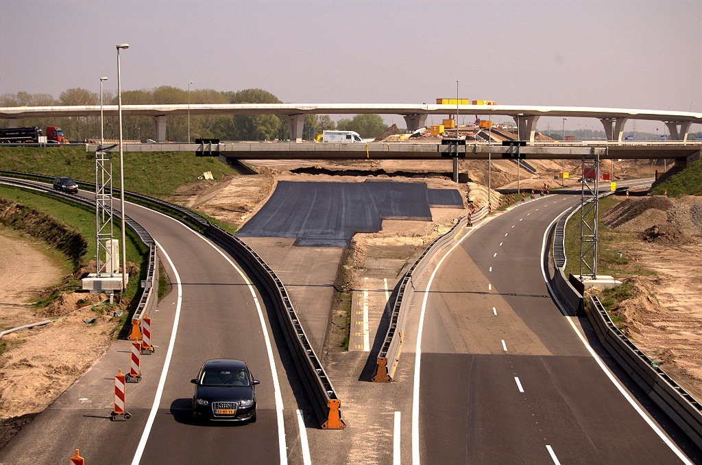 20090418-135632.jpg - Het ziet er wat verloren uit, dit nieuwe asfalt in kp. de Hogt west. De verbindingsweg Amsterdam-Antwerpen en de A67-noord moeten erop komen te liggen, beide dubbelstrooks. Nog een vluchtstrook erbij en je krijgt zo'n breedte. Het belooft nog een spannende fasering te worden, met dat bestaande viaduct in de A2 dat eerst gesloopt zal moeten worden voordat het asfalt kan worden doorgetrokken.  week 200912 