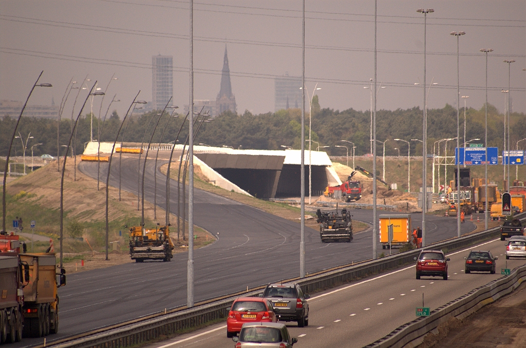 20090419-140510.jpg - Een heleboel nieuw asfalt aan de zuidkant van KW 34. Onduidelijk nog wat het lot gaat zijn van de verbindingsweg vanaf de rotonde. Uiteindelijk komt die bovenop KW 34 te liggen, maar dat zal dit weekend niet in de planning zitten. Er moet dus een tijdelijke (linkse?) invoeger worden aangelegd. De slinger die werd aangekondigd is misschien op dit punt, waar het verkeer dan naar de meest rechtse rijstroken wordt geleid om werkruimte te behouden.  week 200915 