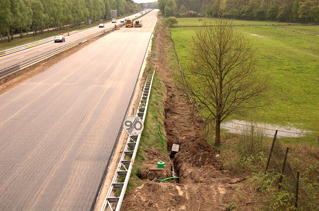 20090419-141034.jpg - ...die, vermoedelijk via een geboorde tunnel, aan de andere zijde van de rijbaan weer tevoorschijnkomen. Ook verder zuidwaarts suggereert een omgewoelde berm dat er kabels zijn begraven.