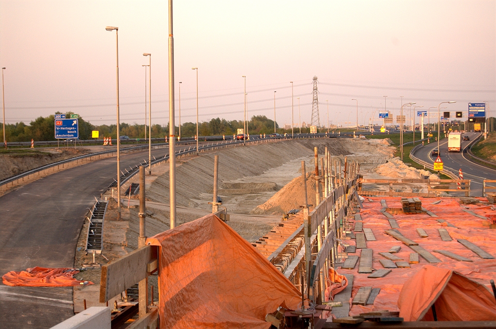 20090424-201249.jpg - De A2 gaat dan vervolgens verder over een nieuw dijklichaam dat aansluit op de A58 vanuit de richting Tilburg. De oude verbindingsboog (rechts), alsmede het zuidelijkste van de drie spoorviaducten in KW 3 worden dan verkeersvrij, zodat het wegvak kan worden herbouwd inclusief de verbindingsweg vanaf KW 4C (rechtsonder) tot een totaal van vier rijstroken.