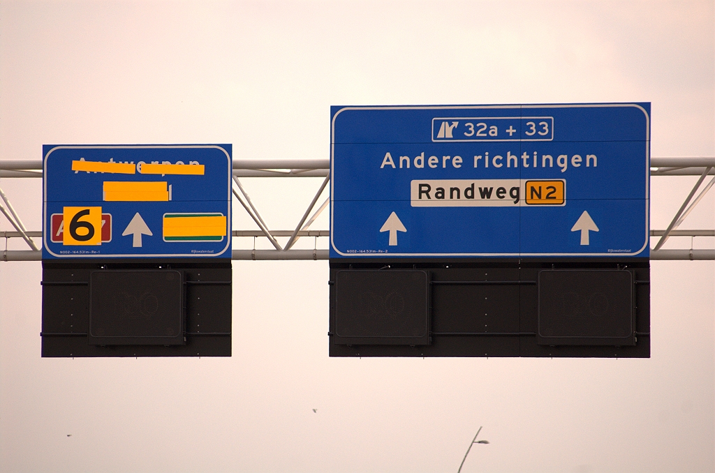 20090429-173309.jpg - Op het  portaal enkele honderden meters eerder  werden de borden nog van plaats verwisseld, om de richting Antwerpen te kunnen aangeven. Deze nieuwe zijn direct in de eindpositie opgehangen. De oude uitvoeger naar Antwerpen blijft voorlopig aangegeven door een tijdelijk mastbord dat in de overzichtsfoto nog net te zien was. In vergelijking met de borden op het eerdere portaal zien we dat in de afritnummers de tekst "t/m" is vervangen door een + teken. Ook het afschaffen van de Randweg Eindhoven gaat door ten voordele van de "Randweg N2".
