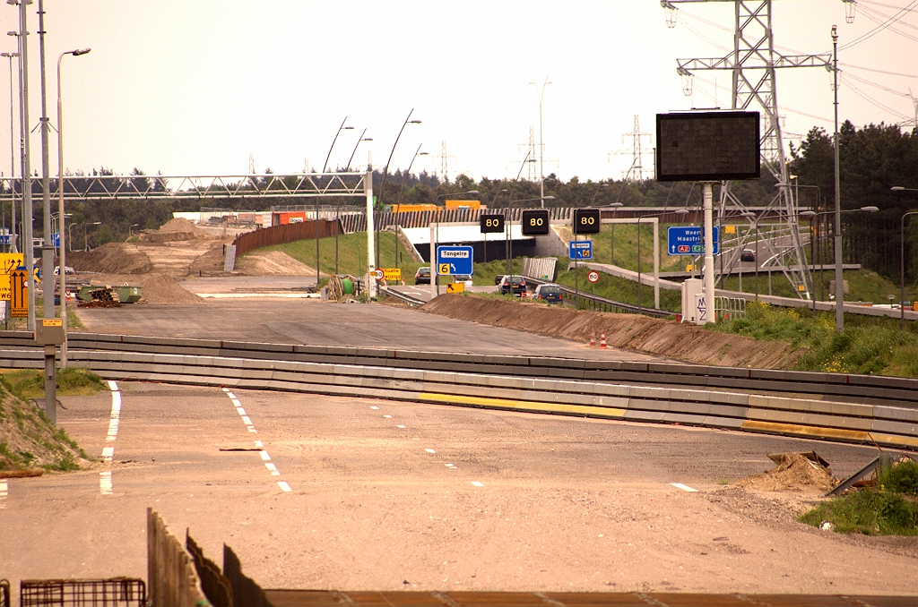 20090509-152256.jpg - Helemaal onderaan nog net een stukje van KW 31, dan puinfundering voor nieuwe zuidelijke rijbaan, vervolgens oude rijbaan, de door  barriers begrensde slinger van zuidelijke parallelrijbaan naar de noordelijke nieuwe hoofdrijbaan en nieuwe zuidelijke rijbaan naar KW 32 (Roostenlaan). Op het viaduct zal de blokmarkering voor de afvallende rijstrook naar de A67-oost al beginnen. Meteen erna volgt een tweede uitvoegstrook. Een gedeelte van het trace tussen KW 31 en KW 32 was al breed genoeg voor de nieuwe rijbaan, wegens de oude A2 TOTSO voor kp. Leenderheide.  week 200914 