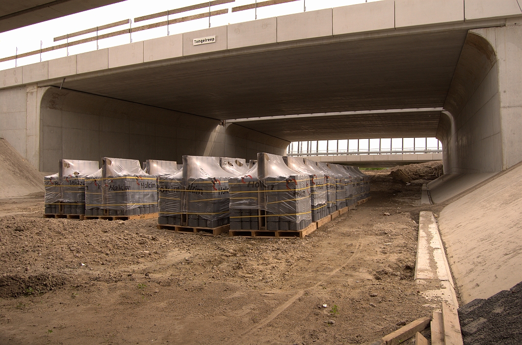 20090509-155448.jpg - Hoofdrijbaanbrug in KW 30 voorzien van naambordje dat voor zichzelf spreekt. Op de parallelbaanbruggen, die vanuit de omgeving als eerste opvallen, zijn geen bordjes aangebracht. Op de pallets gereedliggende taludbestrating, die in de parallelbaanbruggen al een tijd aangebracht is, waarvan rechtsonder nog net een stukje te zien is.