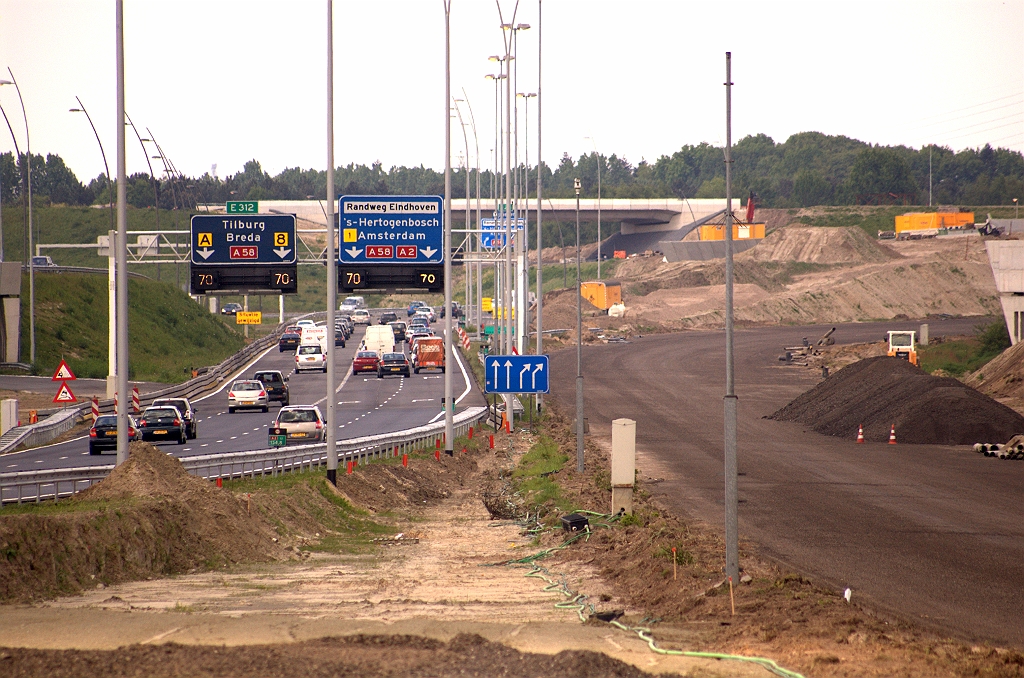 20090510-150709.jpg - Voor de richting Tilburg gaat het vervolgens met twee rijstroken verder over ongeveer het trace van de oude rijbaan, maar in plaats van de bocht in te gaan, gaat het omhoog over het gedeeltelijk aangelegde talud naar KW 5, waarvan we nog net een luifeltje zien.