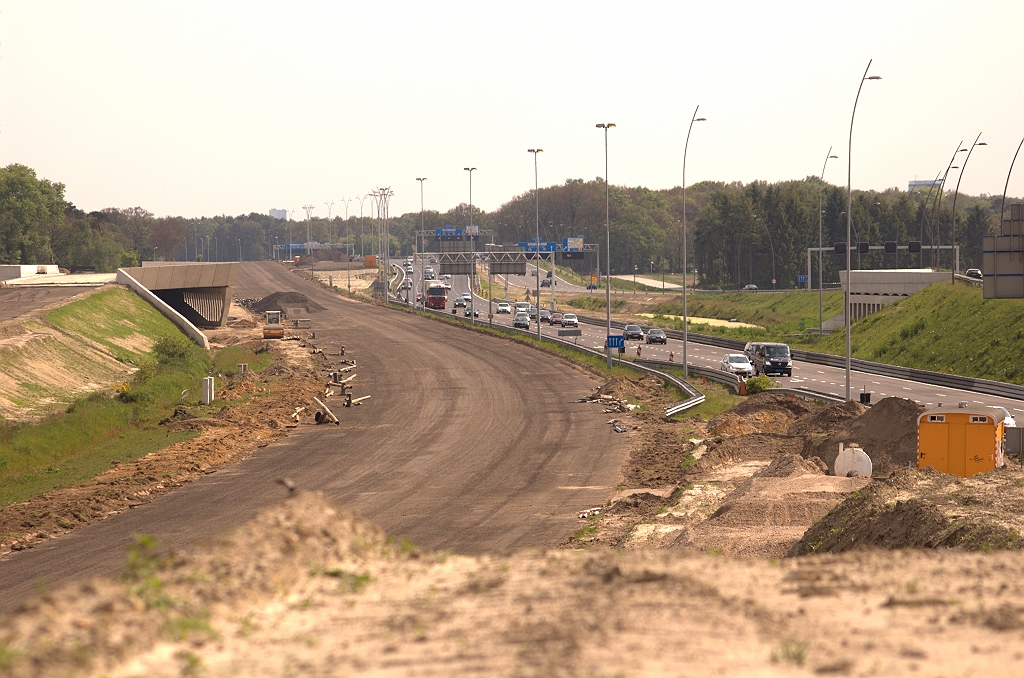 20090510-160510.jpg - Onder KW 7(links) vandaan komen twee rijstroken vanaf de parallelbaan. Van het driehoekje zand in de verte komen twee rijstroken vanaf de hoofdrijbaan. Ze mengen zich tot drie rijstroken en komen dan hier terecht, op het talud naar KW 5 in de richting Tilburg.