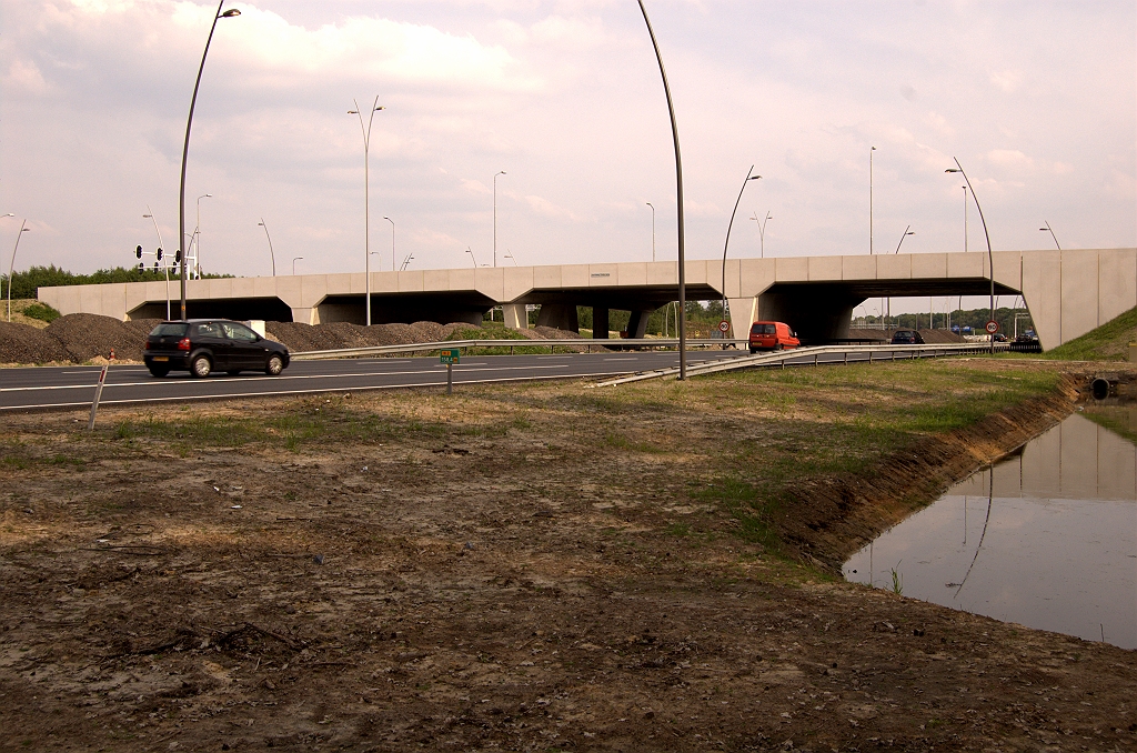 20090510-172843.jpg - Op de betonkolos KW 9 (aansluiting Airport) valt het nieuwe naambordje nogal in het niet. Voor parallelrijbaanberijders is de naam van het kunstwerk kennelijk niet interessant.