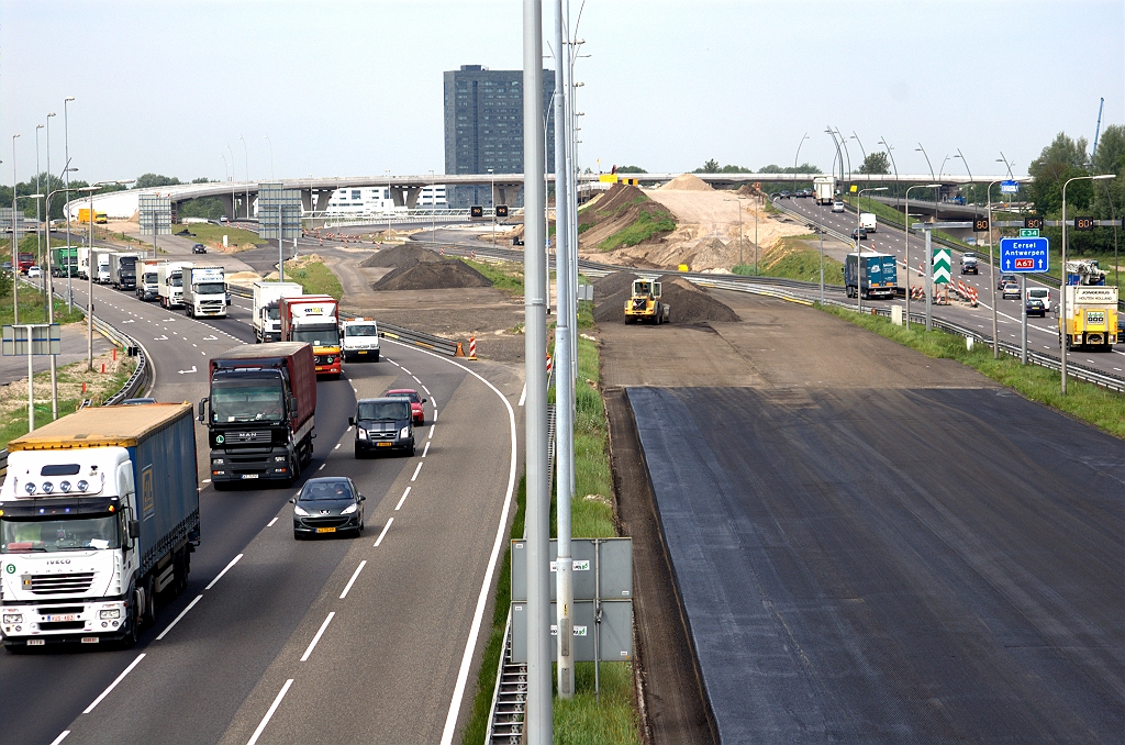 20090513-110306.bmp - Voortekenen van nieuwe faseringen in kp. de Hogt. Zo zijn er van de oude noordelijke A67 rijbaan over de volle breedte een paar lagen afgeschraapt en voorzien van een zwarte substantie (hechtlaag?). Ook is er een strook afgezaagd voor een middenbermverbreding. In de verte ook nieuw zwart bij KW 24, de hoofdrijbaanbruggen over de Dommel.  week 200914 