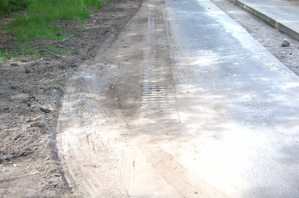 20090521-163844.bmp - De verzaagde rijbaantjes zijn niet breed genoeg voor een normale personenauto. Rechtdoor rijdend moet men al met twee banden van de grasbetontegels gebruik maken. Bij het manoevreren door de onderbreking in de midden"geleider" is het vol in de berm gaan onvermijdelijk. Als de keien zijn aangebracht kan men daar wellicht overheen om de bocht te nemen.