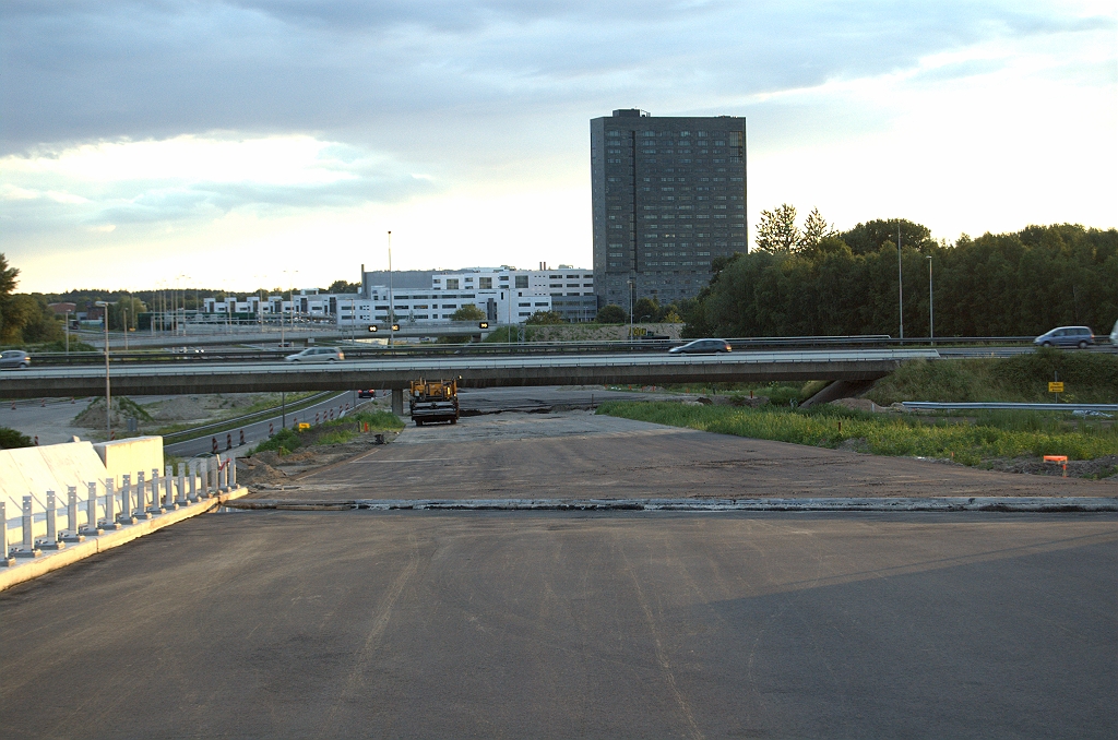 20090621-212206.bmp - Het hellingspercentage is te klein om voor het oude viaduct in de A2 tot op maaiveld te zijn gedaald. Het asfalt stopt dan ook vlak voor dat oude viaduct (KW I). Aan de oostzijde vinden we een  soortgelijke situatie . Mocht de nieuwe verbindingsweg Venlo-Antwerpen in kp. de Hogt in de Grote Omzetting worden opengesteld, dan moet dus KW I worden gesloopt. Dat belooft het spektakelstuk van het lange afsluitweekend te worden. We kunnen dan plaatsnemen op de tribune KW 18, nog net te zien achter de matrixborden, met een uitstekend zicht op de voorstelling. Na de sloop is het voor de hand liggend om ook de nieuwe verbindingsweg Amsterdam-Antwerpen open te stellen. Daar zien we rechts in de foto nog een stukje geleiderail van.