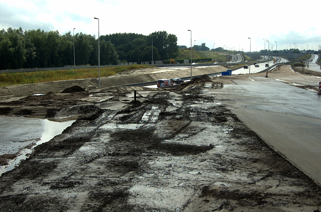 20090712-164001.bmp - Zelfde punt, maar dan in de richting Tilburg waar de noordelijke A58 rijbaan nog in de weg ligt voor het completeren van het nieuwe A50 talud. Een interessante fasering ligt in het verschiet, als het gat moet worden opgevuld. De zuidelijke A58 rijbaan, die al gedeeltelijk op hoogte is gebracht voor het nieuwe A50 trace, is niet breed genoeg voor een 4+0 fasering.