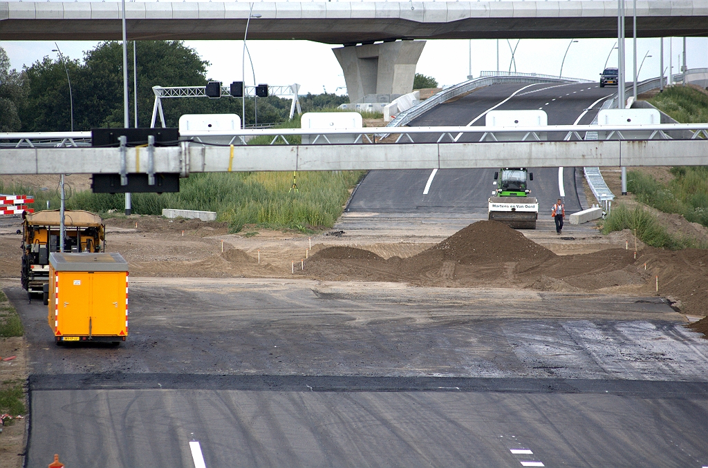 20090718-175308.bmp - Piketpaaltjes geplaatst in het nog te asfalteren deel dat is vrijgekomen door de sloop van het oude viaduct. Trilwals staat klaar om de puinfundering te verdichten.