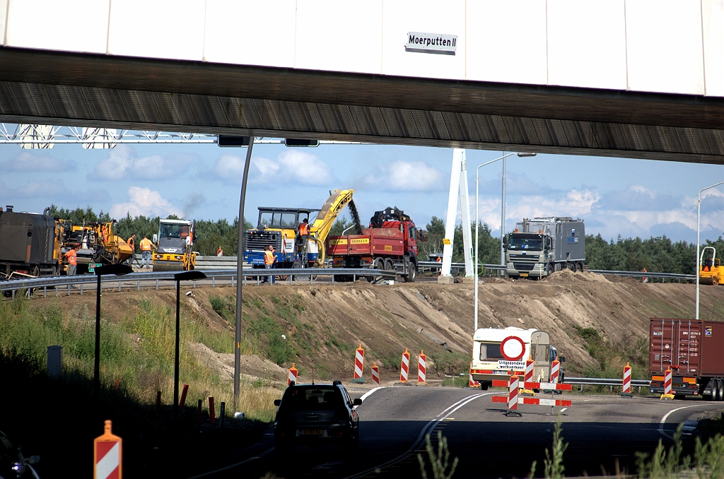 20090725-162106.bmp - Voorpret voor de bestuurders in de richting Venlo die aangeschoven zijn bij de verkeerslichten bij de rotonde: ze kunnen zien dat er hard gewerkt wordt aan het wegvak waar ze over twee dagen overheen mogen rijden.