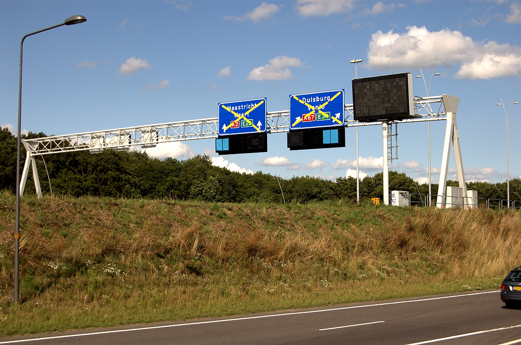 20090725-171352.bmp - Nieuwe borden boven het open te stellen stukje A2 rijbaan. Aan de ingepakte matrixborden is te zien dat men het verkeer richting Venlo via een flauwe slinger naar de dubbele uitvoegstroken gaat leiden.