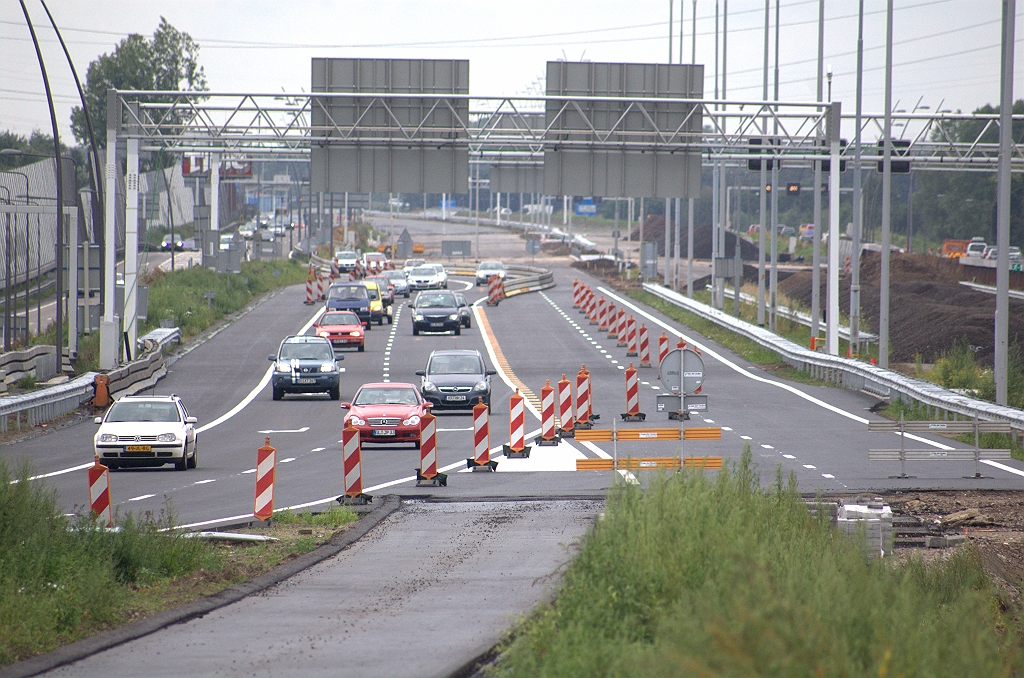 20090802-162724.bmp - Resultaat van de weekeindafsluiting van de A67 in de richting Venlo in kp. Leenderheide, een week geleden. Nieuwe rijbaan in verkeer tussen de aansluiting Waalre en het knooppunt. Vorige fasering rechts reeds bedekt met bergen asfaltschraapsel.  week 200906 