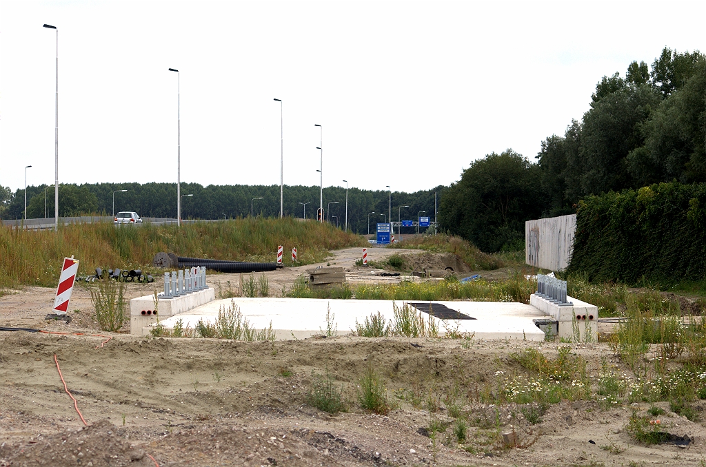 20090809-150408.bmp - Overwoekering dreigt in het tracé van de verbindingsweg Tilburg-Woensel nabij KW 45 (fietstunnel). Toch is er werk gaande, getuige de verwijderde beplanting van een gedeelte van het geluidsscherm.  week 200915 