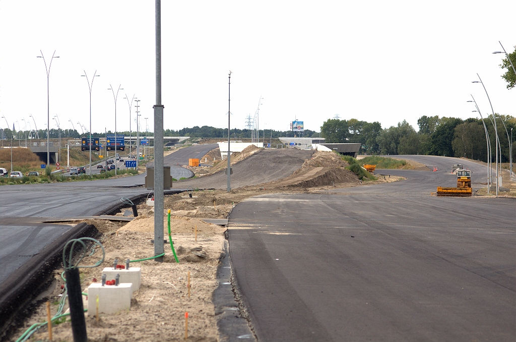 20090809-174053.bmp - Situatie ten noorden van KW 8 met overal asfalt, behalve op de A2 hoofdrijbaan op het talud naar KW 7, waar vooralsnog alleen de AGRAC fundering is aangebracht. De  actuele werkzaamhedenpagina  meldt:  In de periode van 23 tot en met 28 september vinden grootschalige omzettigen plaats bij knooppunt Batadorp. In verband daarmee wordt de A58 richting Eindhoven afgesloten tussen de aansluiting 7 Best en knooppunt Batadorp. De afsluiting is van vrijdag 25 september 20.00 uur tot maandag 28 september 05.30 uur . Dankzij "welingelichte kringen" weten we al wat er te gebeuren staat. Ten eerste verdere openstelling van de parallelrijbaan (rechts) vanaf de aansluiting Airport naar KW 7. Het verkeer in de richting Tilburg gaat dan onder KW 7 door, en verkeer in de richting Amsterdam er rechts langs.  week 200928 