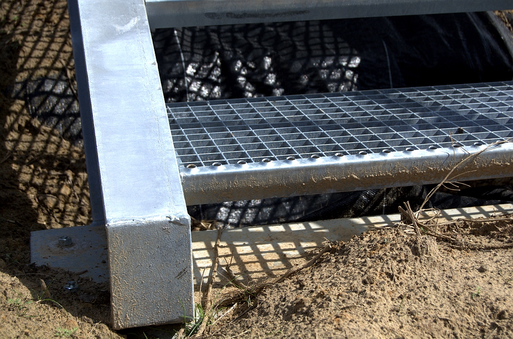 20090829-144621.bmp - Stalen trap is vastgeschroefd aan betonnen funderingsbalken. Eronder worteldoek om overwoekering te voorkomen.