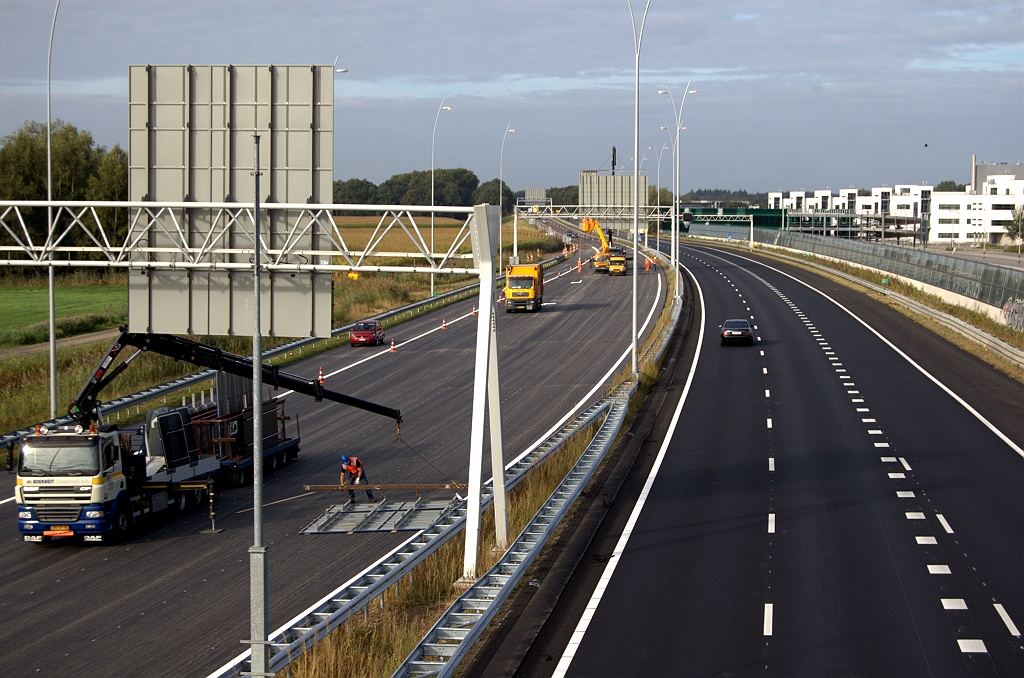 20090912-094635.bmp - Twee uur voor openstelling. De nachtafsluiting van de A67 tussen de aansluiting Eersel en kp. de Hogt is gebruikt om het nieuwe gedeelte met de dubbele uitvoegstroken van een ZOAB deklaag te voorzien. Verkeer mag er weer rijden, over de vluchtstrook.  week 200936 