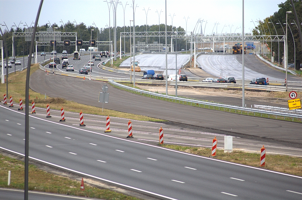 20090913-160614.bmp - Parallelbaan oost (rechts) tussen de aansluiting Airport en kp. Batadorp, twee weken voor openstelling. Men is bezig de hechtlaag aan te brengen voor het DZOAB. Ook de nog niet open te stellen hoofdrijbaan (rechtsmidden) is ingesmeerd.  week 200936 