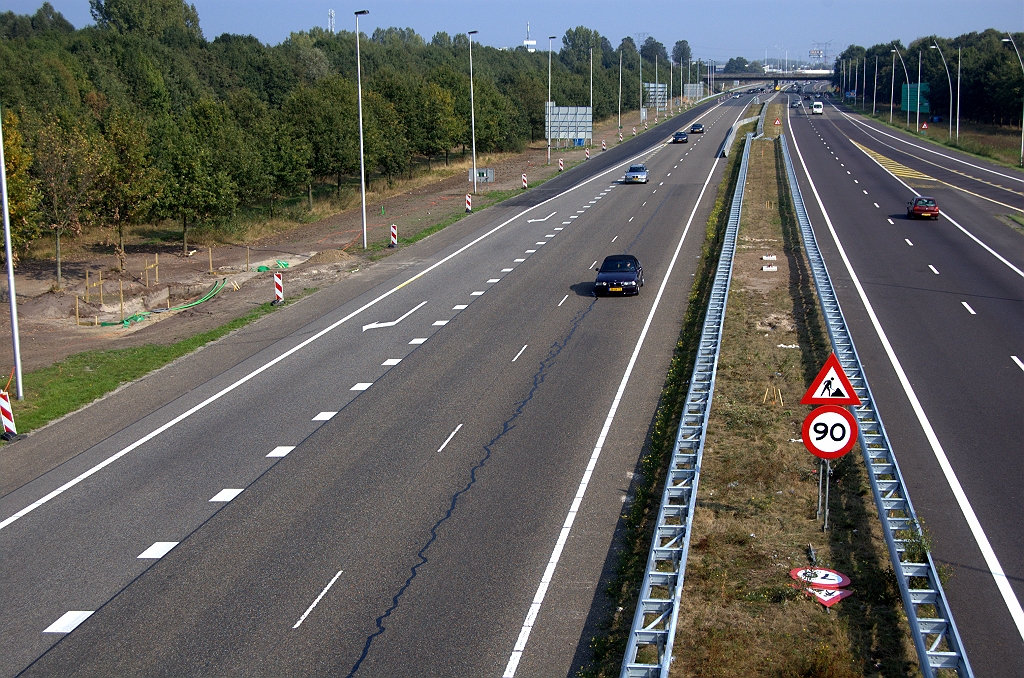 20090927-144134.bmp - Ook poeren langs de noordelijke A5(0/8) rijbaan tussen het viaduct Huizingalaan en het knooppunt Ekkersweijer. Gezien de groene kabels komt er signalering aan te hangen, maar misschien ook wel portaalborden. Geleiderails verdubbeld voor botsveiligheid met de te plaatsen portalen, maar vast ook voor lichtmasten (zie het piketpaaltjes-triplet) op het voorheen onverlichte wegvak. Van verbreding van de zuidelijke rijbaan (rechts), zoals we eerst hoopvol dachten, is dus geen sprake.  week 200937 