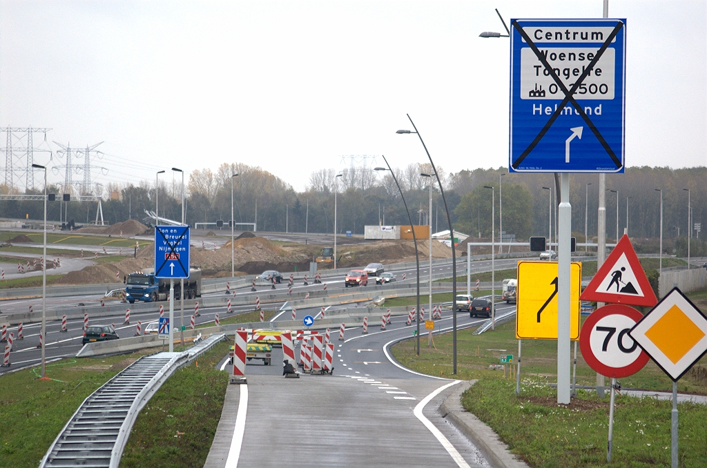 20091024-154218.bmp - Twee nieuwe mastbordjes in de toerit in de aansluiting Ekkersrijt in de richting Nijmegen. Ze zijn nodig voor verkeer Ekkersrijt-Woensel, maar ook voor verkeer vanuit de richting Tilburg dat via de rotonde in de aansluiting zijn weg zoekt naar Woensel. De bypass heeft immers maar 1 rijstrook. Ondanks de omhoogwijzende pijlen zijn het klassieke bordjes met de doelen in conventionele volgorde zodat bijvoorbeeld het doel Helmond helemaal onderaan staat. Op de  portaalborden vanuit de richting Nijmegen  is dit omgekeerd.  week 200939 