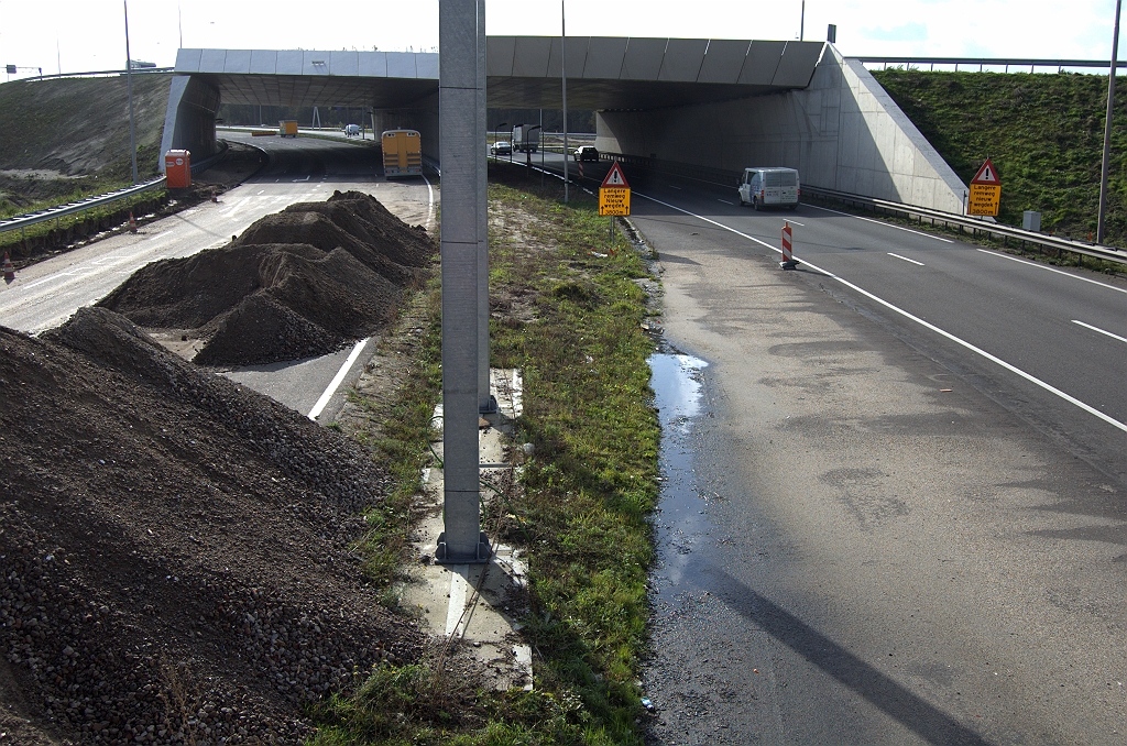 20091025-135338.bmp - En weer met de rijrichting mee. Het oversteekasfalt brengt het verkeer vlak voor KW 5 op de parallelrijbaan, die vanaf dat punt al zijn definitieve verschijningsvorm heeft met ZOAB.