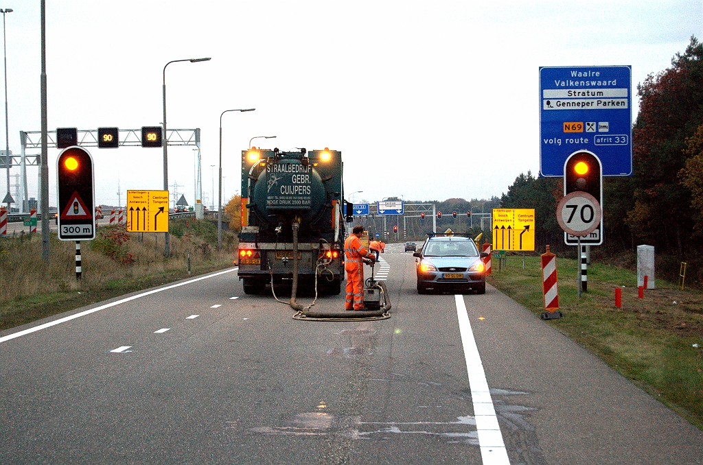 20091031-175942.bmp - Nieuwe indeling van de opstelstroken voor de rotonde zichtbaar op de gele borden. Rechtsaf richting gaat terug van twee naar 1 rijstrook, zodat men bezig is met het wegstralen van de blokmarkering.