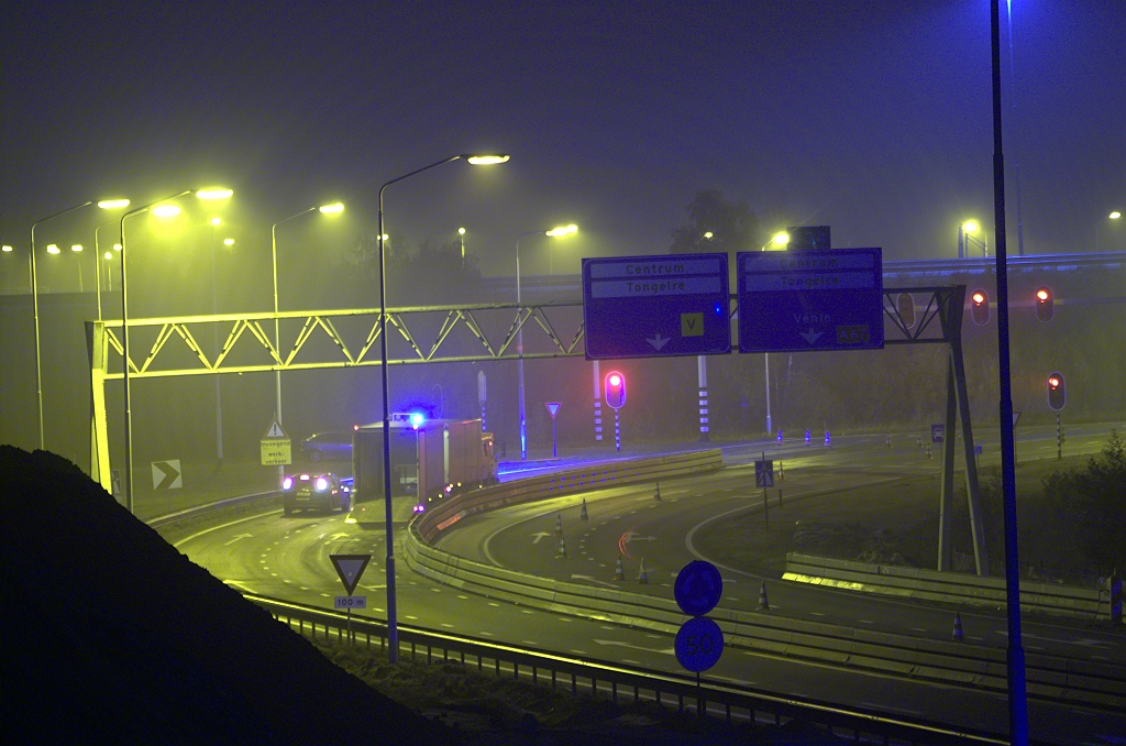 20091101-041629.bmp - Nieuwe inrichting van de opstelstroken vanaf de A2 naar de rotonde. Verkeer rijdt tijdens de nachtelijke werkzaamheden rechts van de barrier, maar dat zal over enige uren aan de linkerkant zijn, zodat er een werkvak rechts van de barrier onststaat waar de definitieve rijbaan gaat worden aangelegd. Volgens de tracekaart gaat het aantal opstelstroken terug van vijf naar twee. Grootste van de drie portaalborden reeds verwijderd, de andere twee zullen er ook aan moeten geloven.  week 200930 