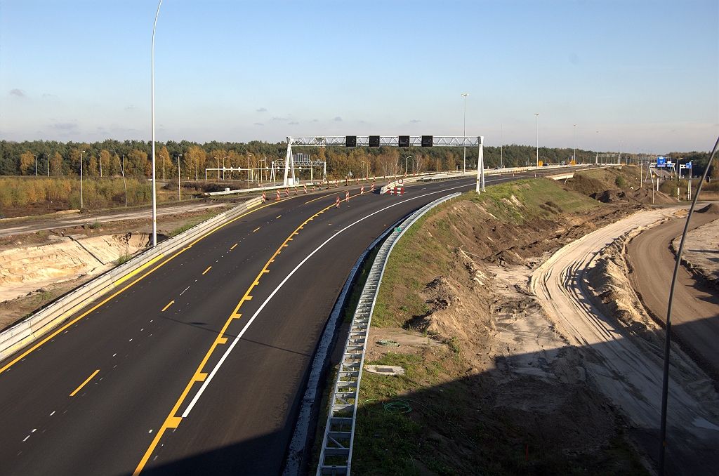 20091108-142339.bmp - Ook aan de A67 rijbaan in de andere (oostelijke) richting is wat veranderd. Hij loopt via een slinger naar de andere rijbaan die, dankzij de fasering van het verkeer uit de richting Venlo over de rotonde, vacant was. Daardoor kan er nu gewerkt worden aan de twee oude viaducten in de zuidelijke rijbaan. Rechts het opgebroken einde van de zuidelijke parallelrijbaan naar de rotonde.  week 200931 