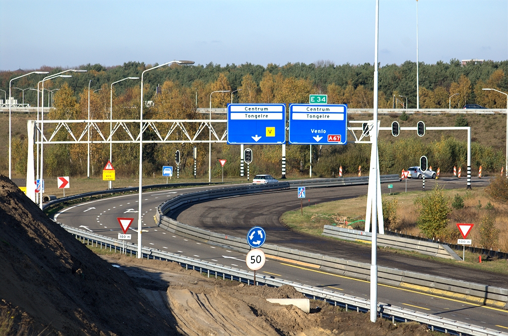 20091108-144851.bmp - Verwarrende positie van de nog overgebleven portaalbordjes boven het al afgeschraapte deel van de voormalige A2 rijbaan naar de rotonde. Het verkeer rijdt dus thans links van de barrier.  week 200944 