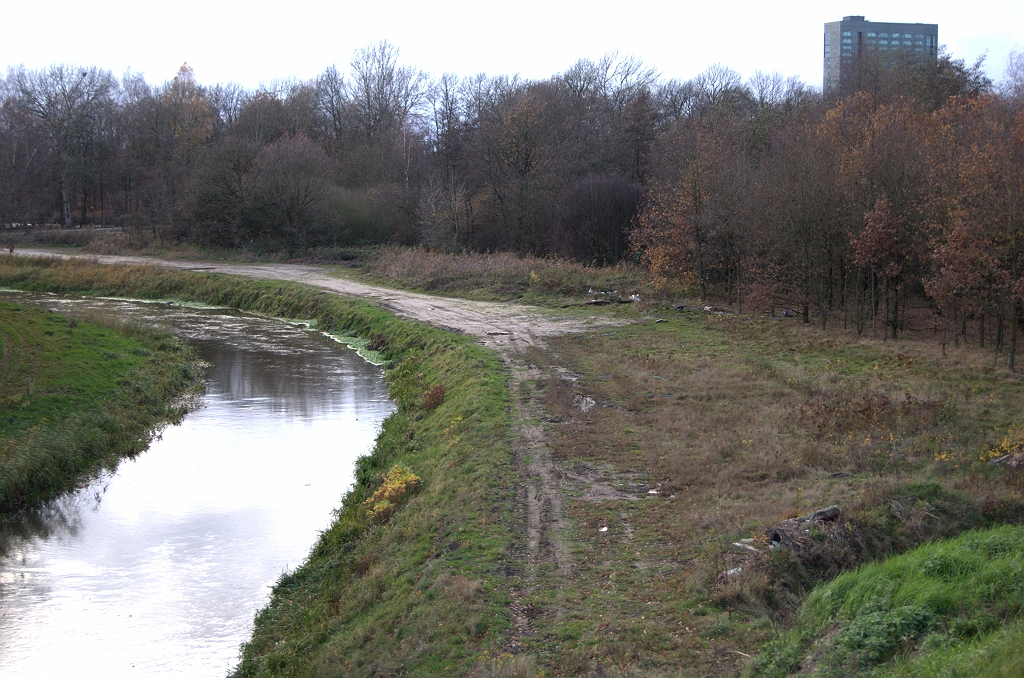 20091122-172503.bmp - Zuidwestzijde van het knooppunt. Tot 1987 scheerde hier de enkelstrooks verbindingsweg Amsterdam-Maastricht in de vorm van een krappe klaverlus langs de rechteroever van de Dommel. Met een beetje goeie wil kan men aan de verschillen in begroeing nog zien waar de lus gelegen heeft. Op een foto op  watwaswaar.nl  uit 1992 is het trace nog duidelijk te herkennen.