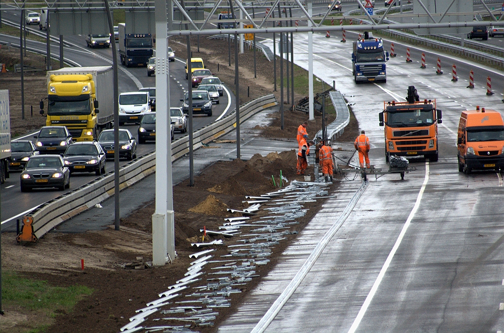 20091126-154158.bmp - Flinke inzet van personeel dat geleiderail plaatst. De indruk ontstaat dat de openstelling van de fasering een kwestie van dagen is.