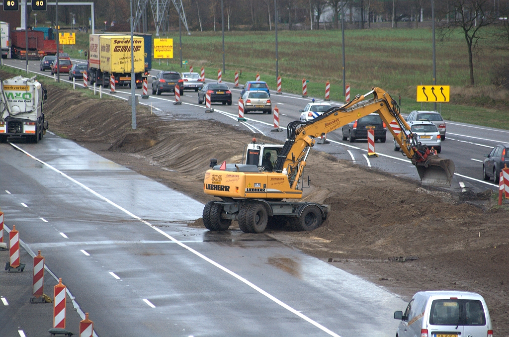 20091126-154550.bmp - Afwerken berm tussen hoofd- en parallelrijbaan op de plek waar de slingerfasering gelegen heeft, waarbij een RWS cameramast enigzins in de weg staat.