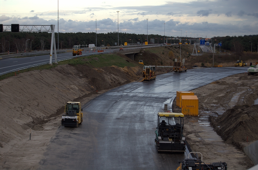 20091128-155321.bmp - Meer nieuw asfalt, nu in de opstelvakken aan het einde van de parallelrijbaan bij de rotonde Leenderheide. De verbreding van twee naar vier (of vijf?) rijstroken is in wezen het herstel van de situatie van voor 1996, toen er nog geen bypass was en al het doorgaande A2 verkeer in de richting Maastricht bij de rotonde moest aanschuiven.  week 200946 