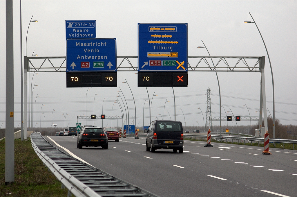 20091206-141912.bmp - Op het tweede beslisportaal is het rechter bord vernieuwd. Voorheen hing daar een klassiek model met vallende pijlen, dat na negen maanden dienst kan worden gerecycled. De geintegreerde afritnummers maken een nieuw tijdelijk opzetbordje voor het linkerbord noodzakelijk, dat voor de gelegenheid ook is voorzien van de lokale doelen.  week 200911 