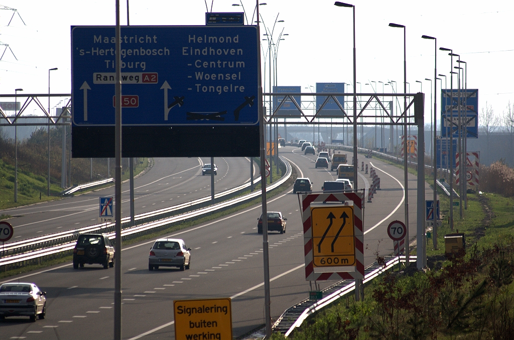 20091212-133246.bmp - Het beeld van een nagenoeg onbedorven A50 verandert ingrijpend aan de zuidzijde van de aansluiting Son en Breugel. Aan het woud van nieuwe portalen en nieuwe/tijdelijke lichtmasten is nog maar een uitzichtbederver toegevoegd. Toch is al iets te zien van de nieuwe verkeerssituatie die de afgelopen nacht (12 december 2009) van kracht is geworden: een rechtse slinger vervangt de linkse van voorheen.  week 200947 