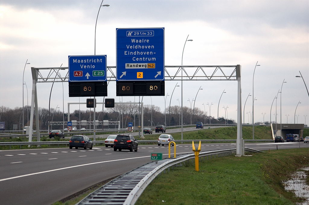 20091212-144313.bmp - Op de foto helaas niet goed zichtbaar de linksaf pijlen die op de rijstrook links van de de blokmarkering zijn aangebracht. Op het portaalbord erboven staat een rechtdoorpijl. Voor de N2 moet men volgens de borden rechtsaf slaan, maar er staan geen corresponderde pijlen op het wegdek. Zulk soort discrepanties zien we op een aantal locaties in de Randweg Eindhoven.  week 200939 