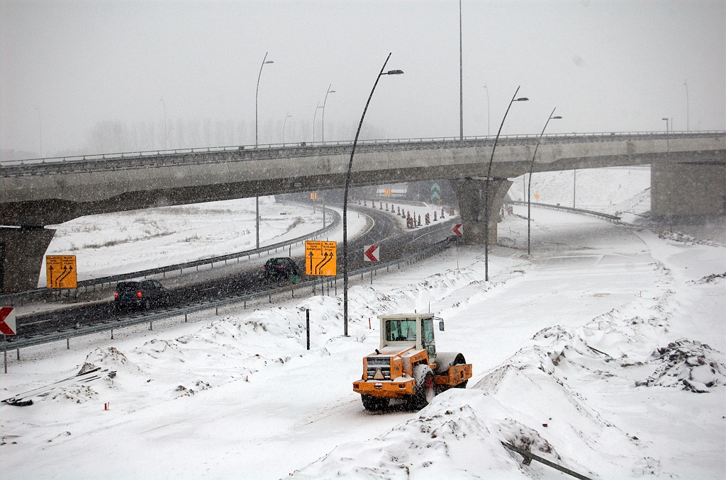 20091220-145727.bmp - Nee we gaan verder geen sneeuw meer wegkrabben. Ongetwijfeld is er geen nieuw asfalt aangebracht in het cunet van de parallelrijbaan rechts (waar de trilwals staat).  week 200949 