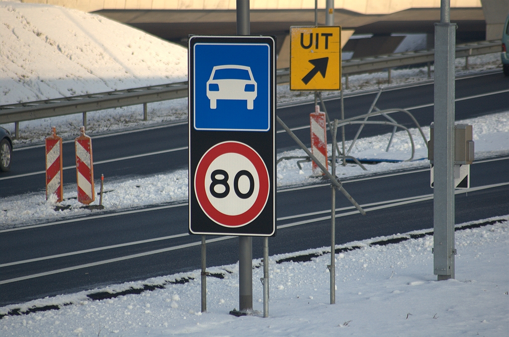 20100103-155040.bmp - ...waar we dit combobord G3/A1-80 aantreffen, dat er al enige weken staat. Zulke borden beloven de standaard begroeting te worden voor wie met 120 km/uur komt aanrijden vanaf de A2, A50, A58 of A67 met een lokale bestemming op de Randweg Eindhoven. Deze is vooralsnog in een tijdelijke vakwerkconstructie rondom een lichtmast aangebracht. Op de achtergond de vervrongen staalconstructie van wat eens een NBA "UIT" bord is geweest.