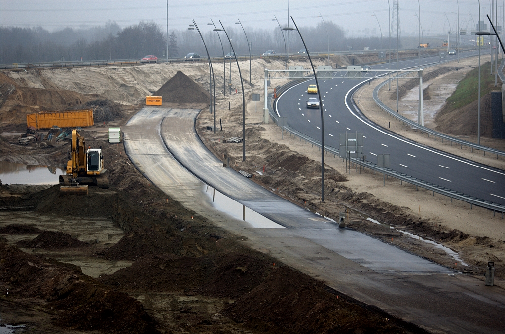 20100206-160600.bmp - Nog meer nieuw asfalt, nu in de parallelrijbaan vanuit de richting Amsterdam in kp. Batadorp. Het lijkt misschien wat voorbarig om dit relatief kleine stukje nu al te draaien, terwijl voor aansluiting vanuit kp. Ekkersweijer toch eerst dat dijklichaam met de oude verbindinsgweg Nijmegen-Breda moet zijn gesloopt. Maar gezien de weersomstandigheden is elke dag zonder vorst een geschenk dat meteen benut moet worden uiteraard.  week 200950 