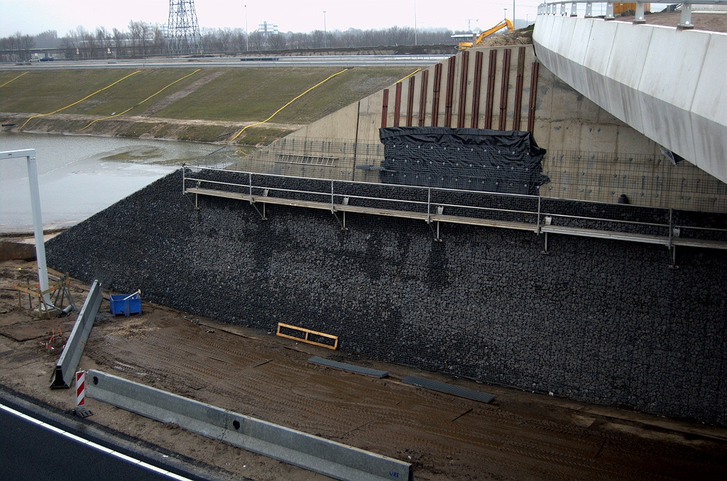 20100206-174809.bmp - De merkwaardige houten latjes op het oostelijk landhoofd in KW 44 lijken onder de steenkorfbekleding te gaan verdwijnen. Hun nut blijft aldus een raadsel.