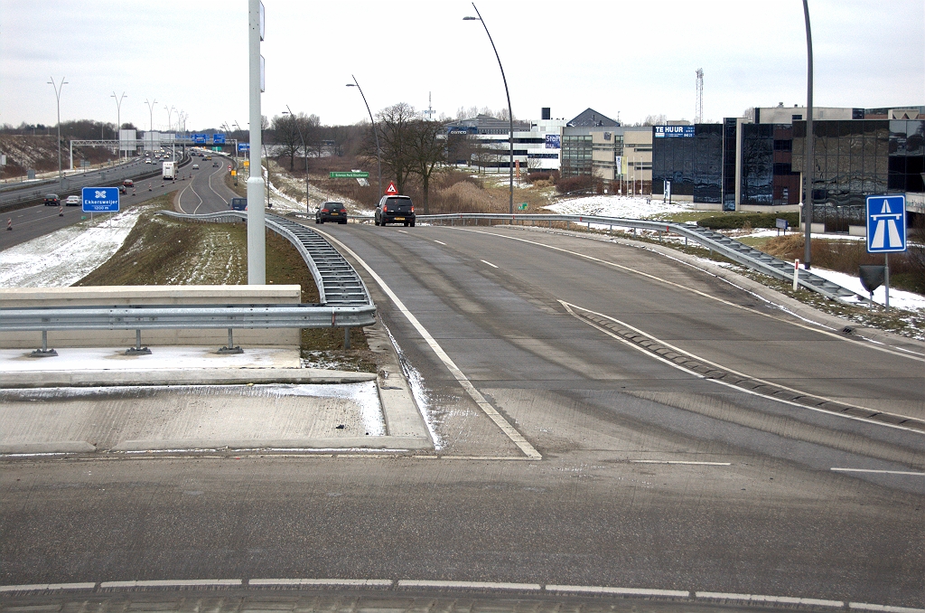 20100213-155336.bmp - Op het eerste gezicht ligt de toerit in de richting Breda er nog hetzelfde bij als toen hij werd geopend op 27 maart 2009. Naast het bord G1 uiterst rechts zien we echter een vuilniszak.